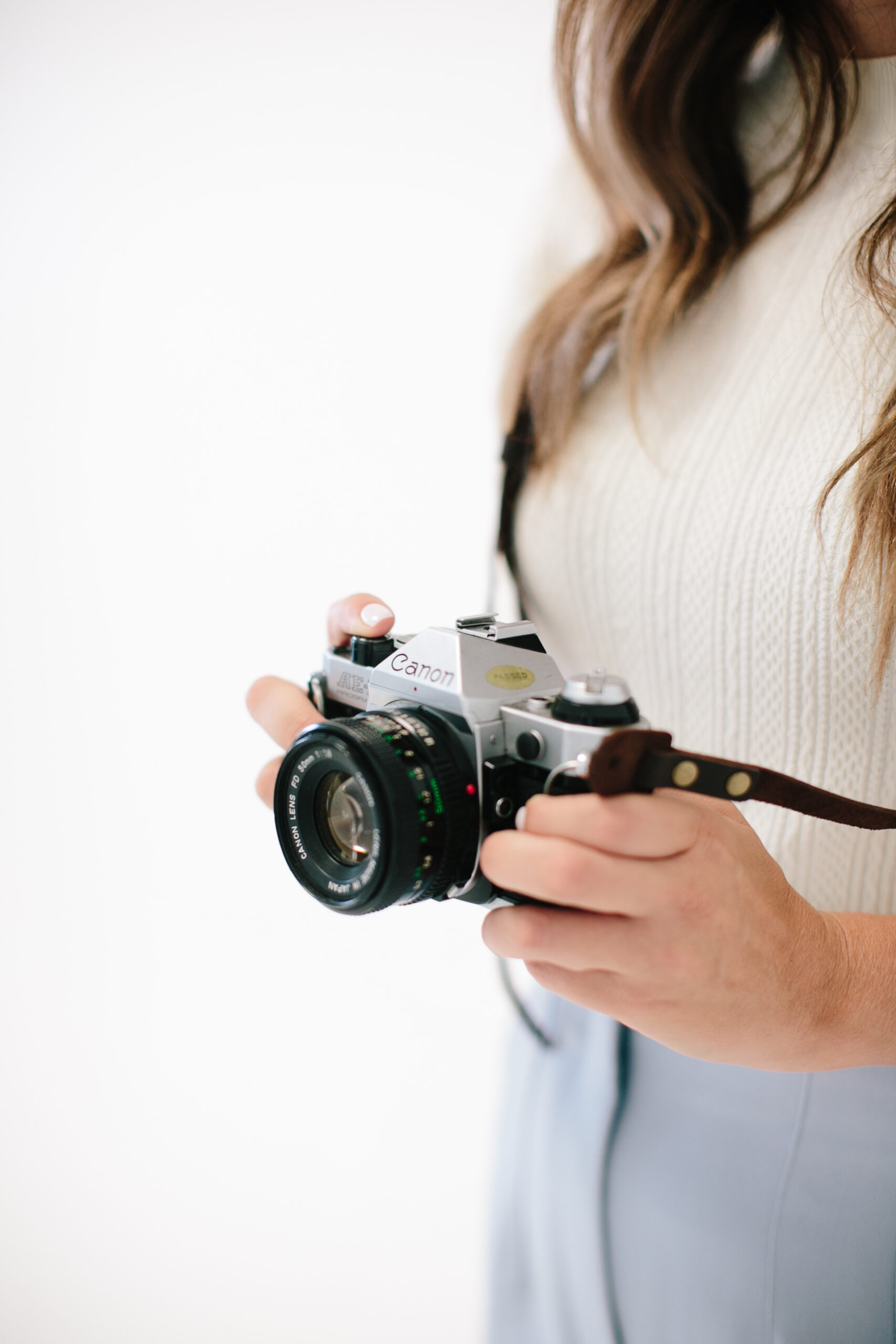 Female artist holding a vintage-style camera, ready to capture creativity.