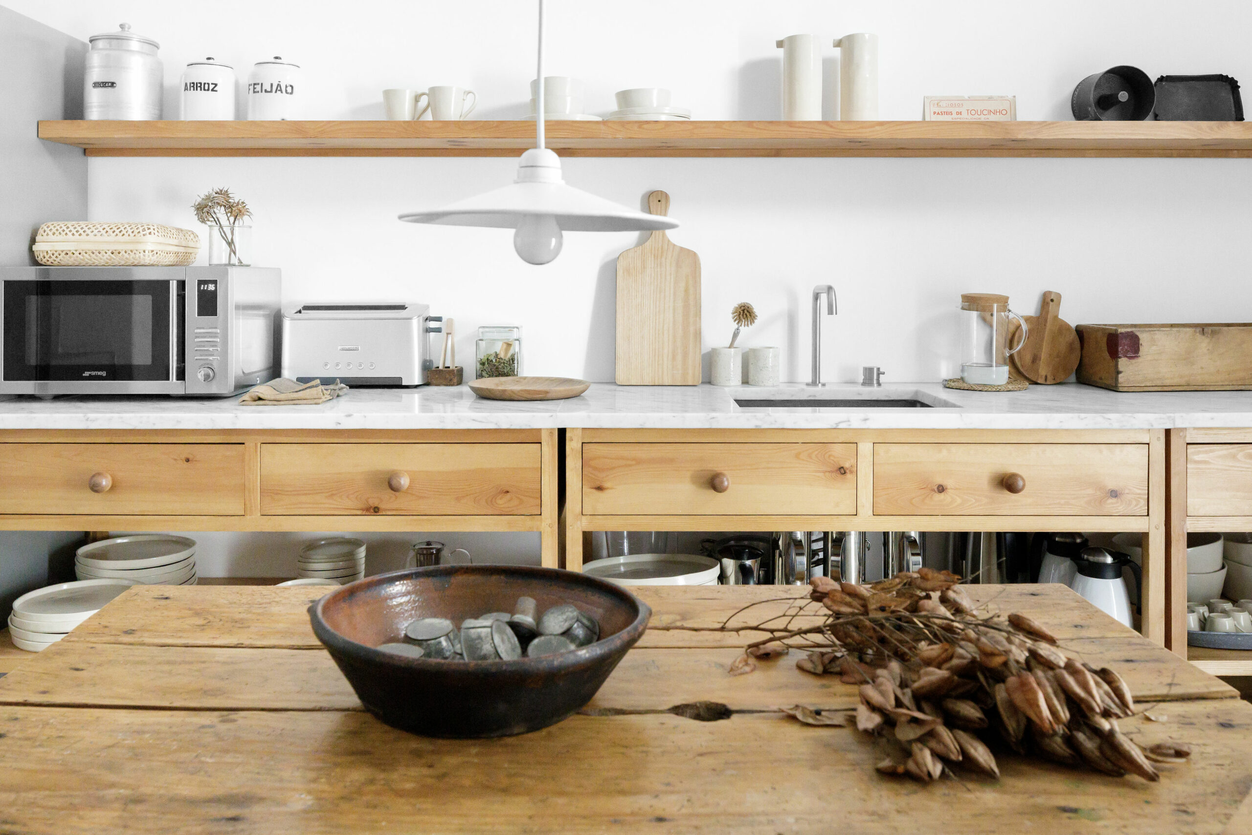 A modern kitchen with fresh white cabinets and oiled wood countertops.